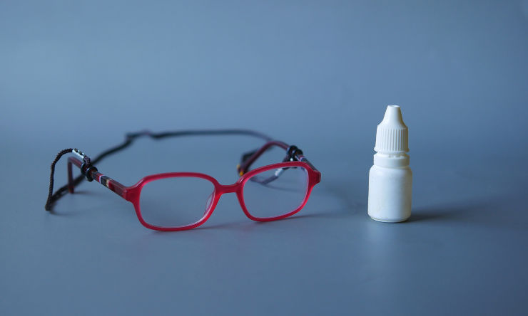 Glasses and an eye drop bottle
