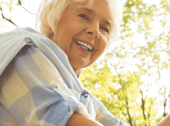 Older woman in sunny leafy setting